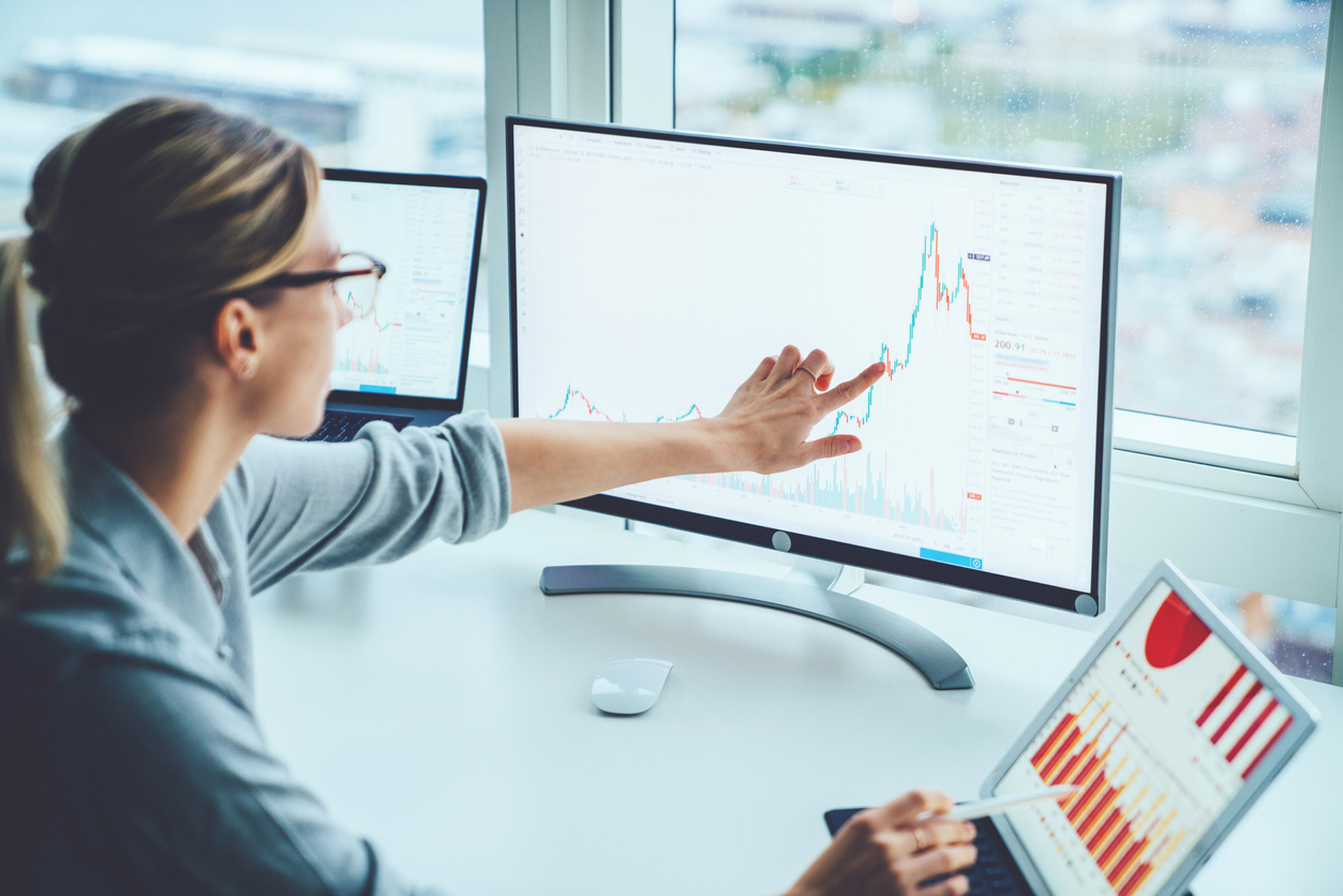 Sellerdeck Business woman study financial market to calculate possible risks and profits.Female economist accounting money with statistics graphs pointing on screen of computer at desktop. Quotations on exchange